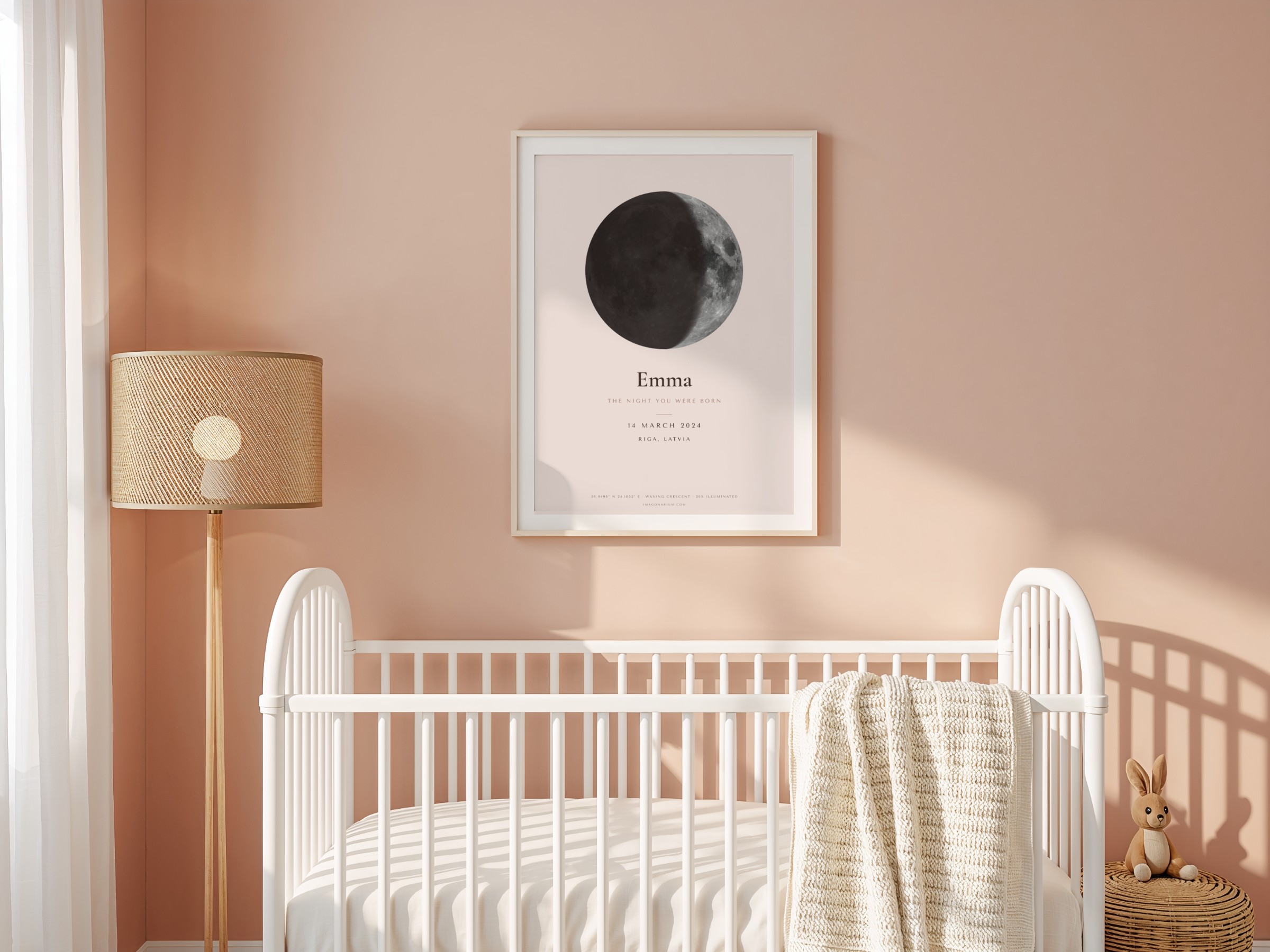 Personalised moon print for a new baby, framed above a crib in a blush nursery